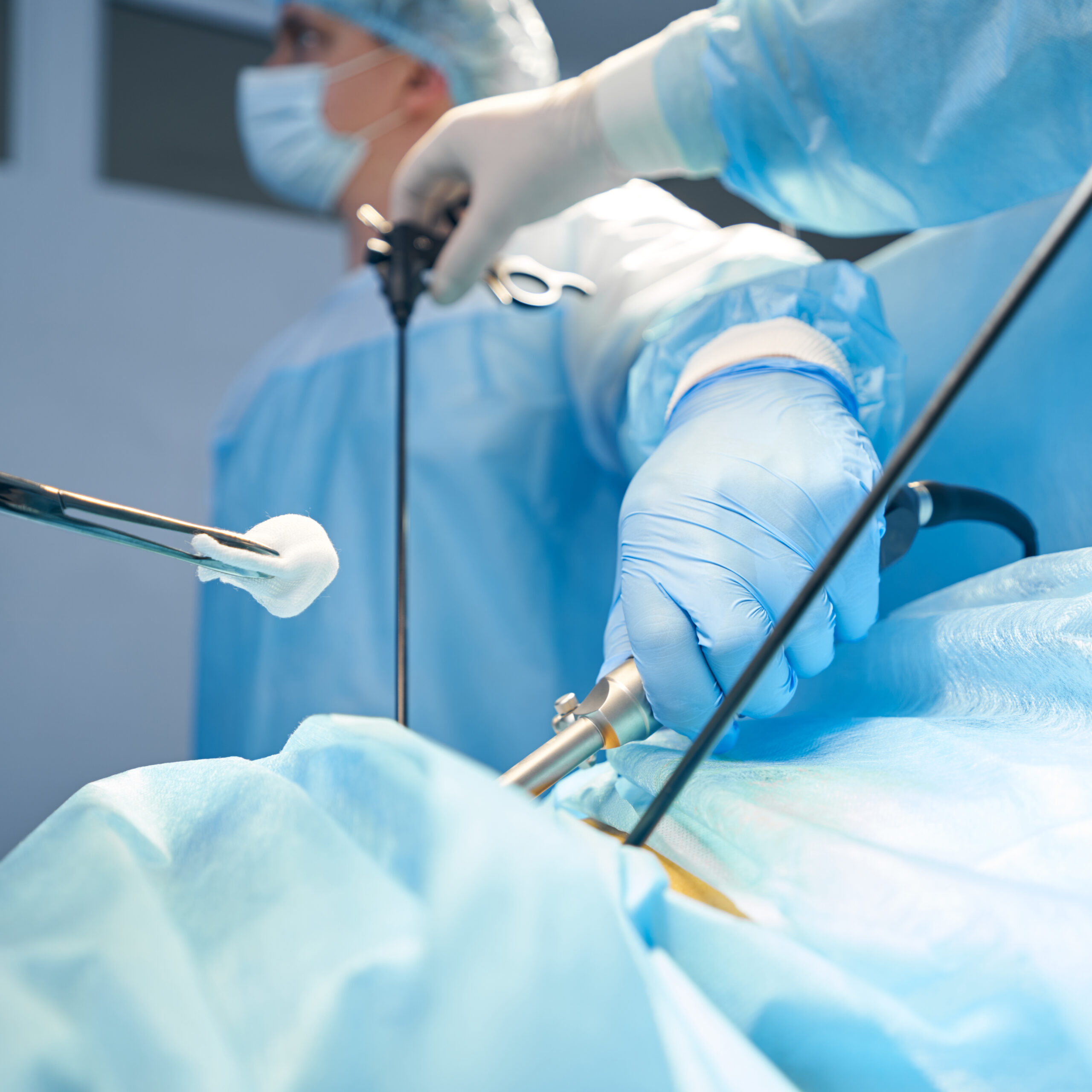 Surgery specialist bringing gauze to abdomen incision